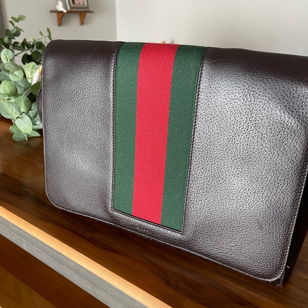 Gucci dark brown leather messenger bag with vintage stripes in used condition.